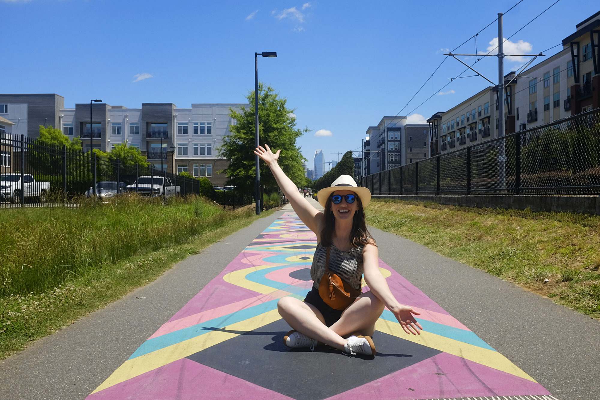 Alyssa sits on the Rail Trail in Charlotte and is wearing the belt bag