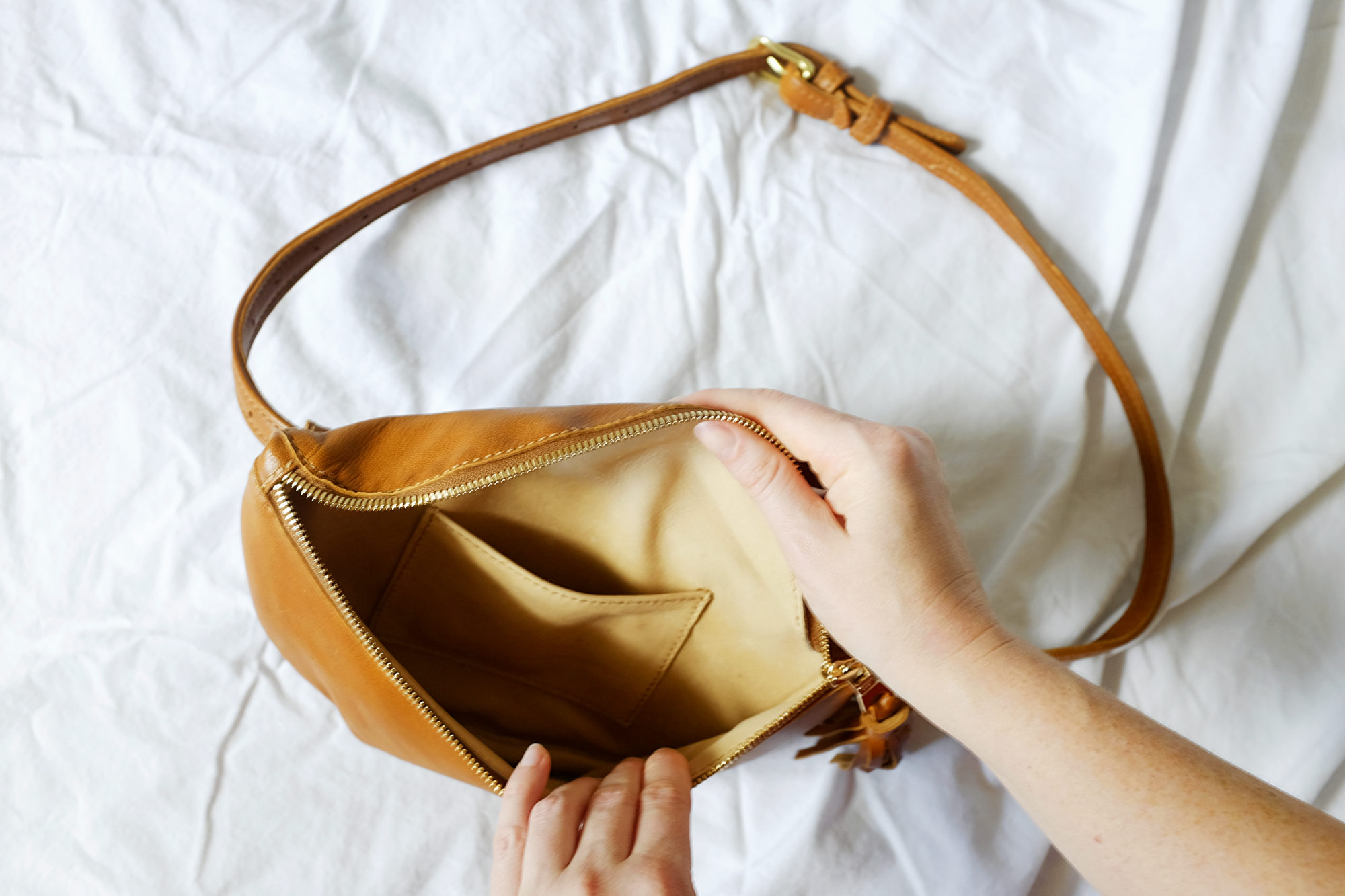 Alyssa holds the Sodo Belt Bag open to show the size