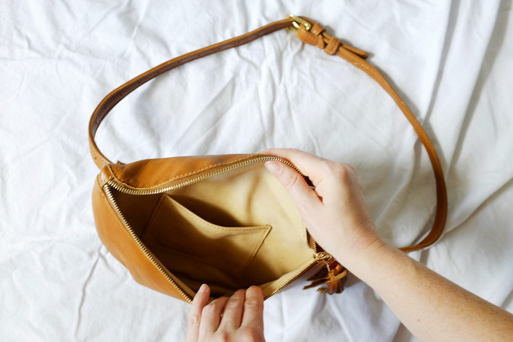 Alyssa holds the Soto Belt Bag open to show the size