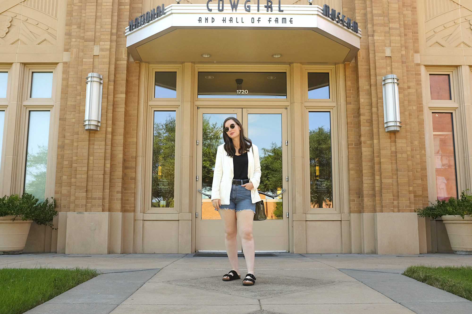 Alyssa wears denim shorts and a white blazer in Fort Worth