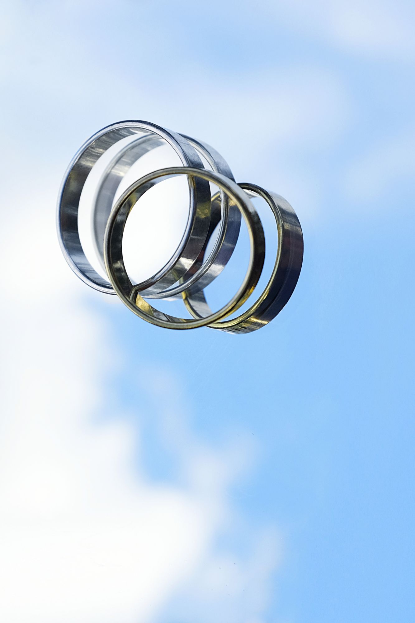 Two rings reflect sunlight and sky from below