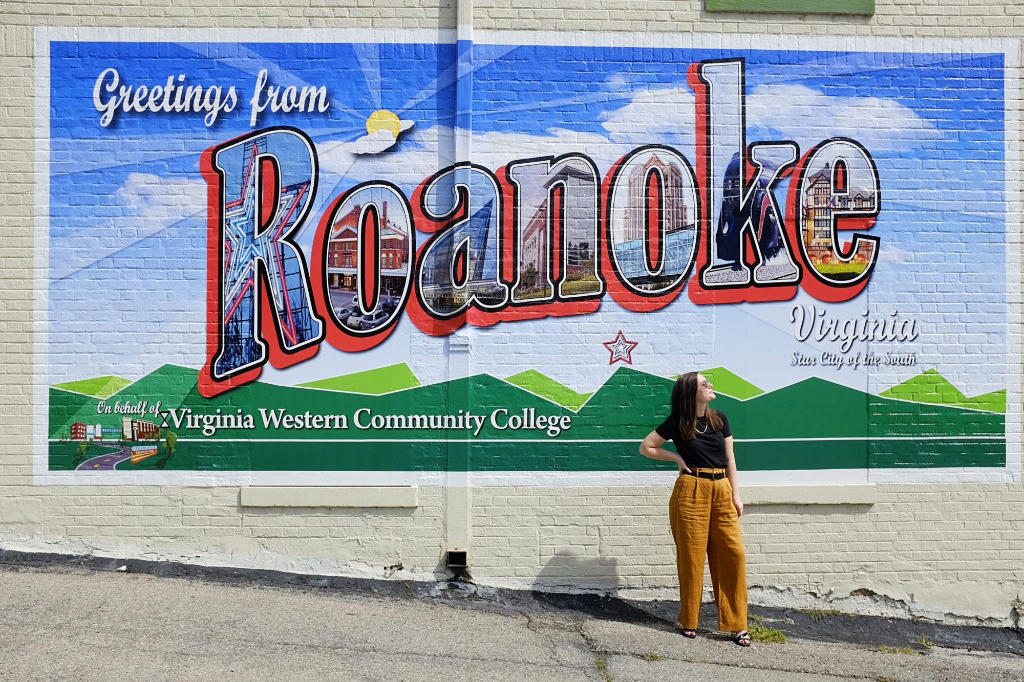 Alyssa stands in front of the Greetings from Roanoke sign