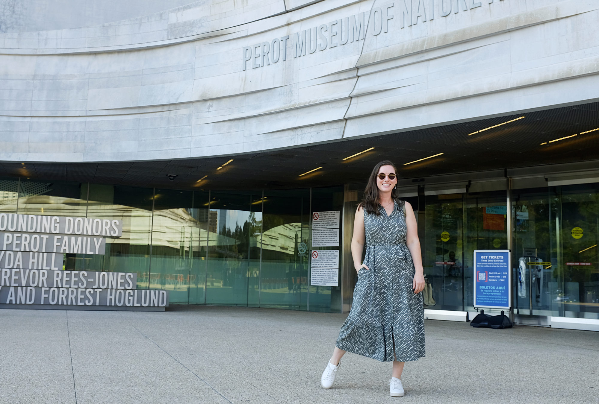 Alyssa wears a green polka dot midi dress with sneakers