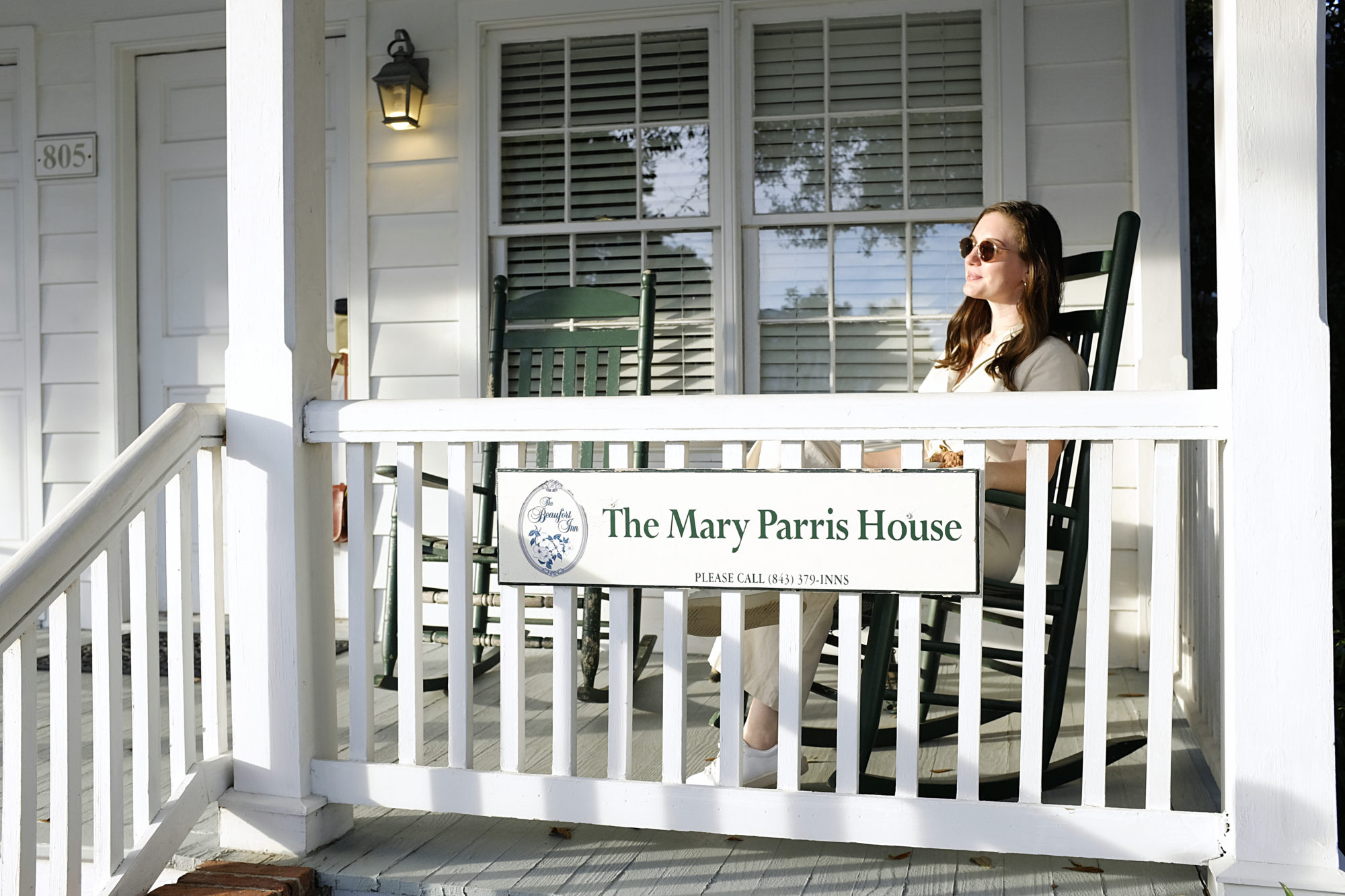 Alyssa sits on the Port Republic Cottage porch at The Beaufort Inn