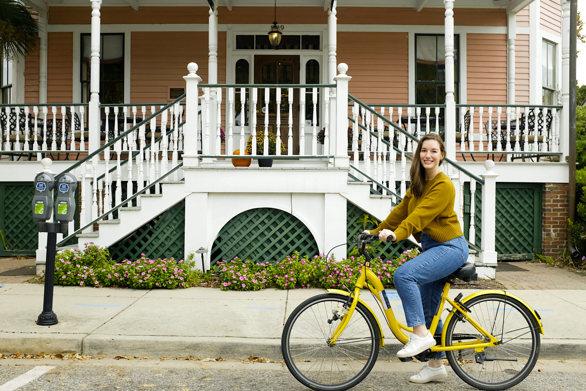 Alyssa rides a bike in front of The Beaufort Inn