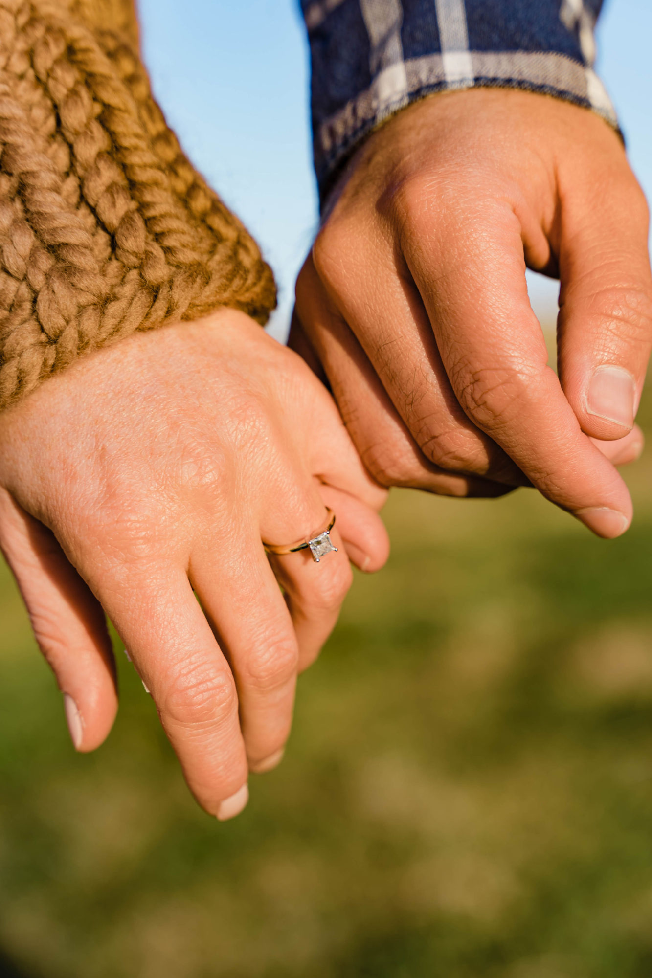 Alyssa and Michael pinky promise; Alyssa is wearing a gold band set with a princess cut diamond in platinum prongs