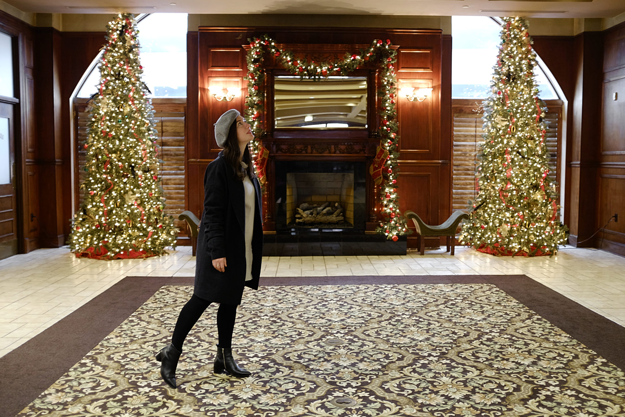 Alyssa stands in the lobby of the Carnegie Hotel at Christmastime