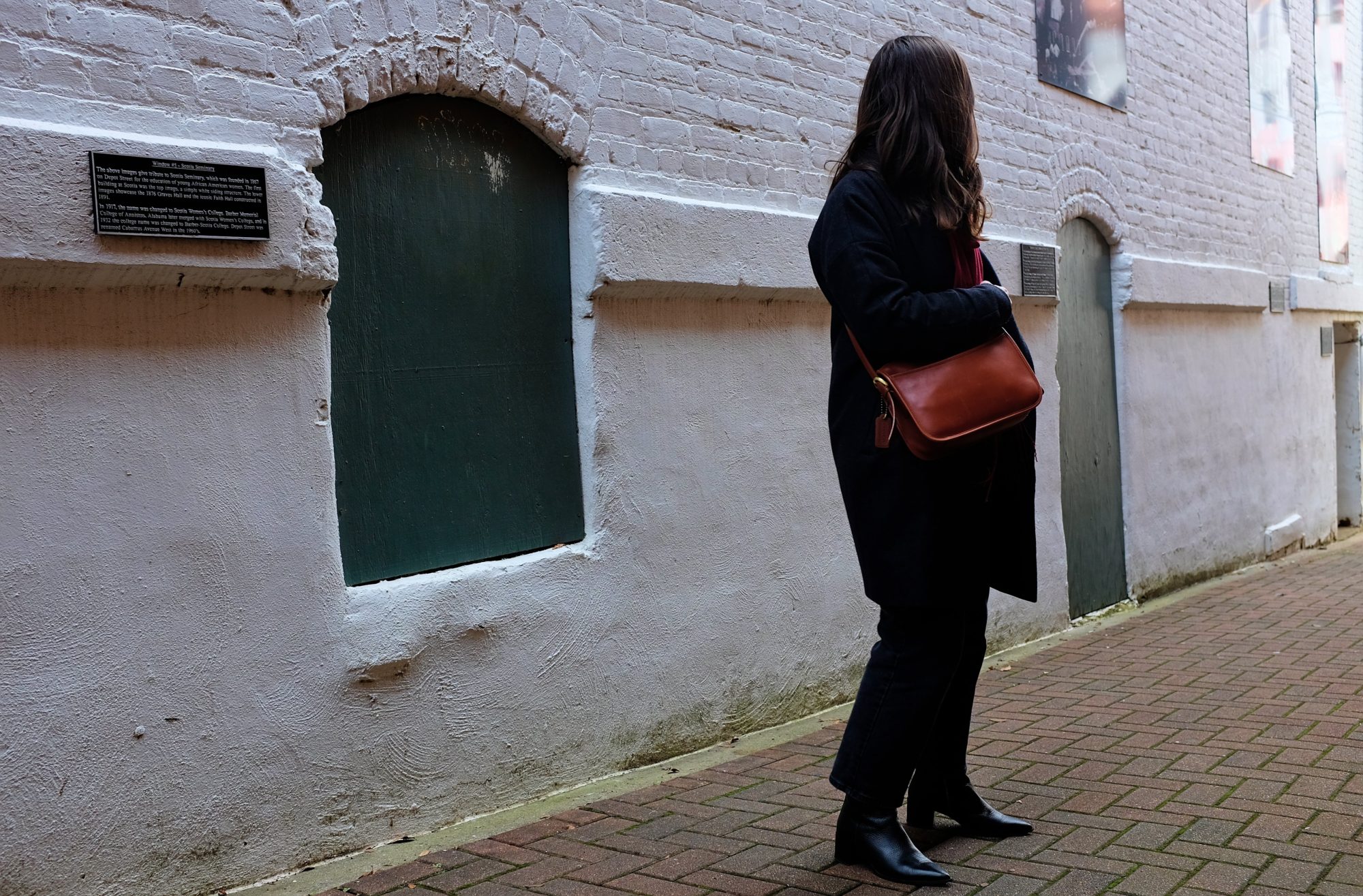 Alyssa stands in an alley near Mac Tabby