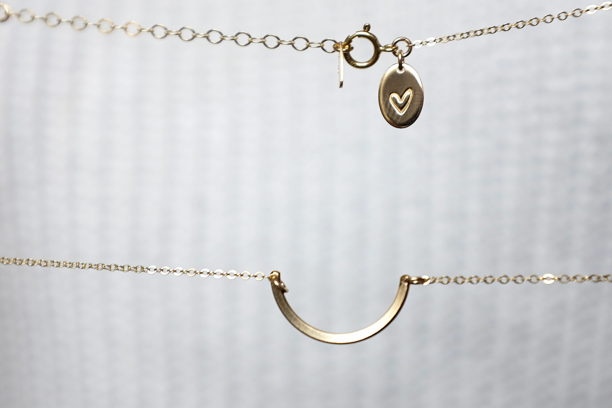 One half-circle necklace with a heart oval at the clasp