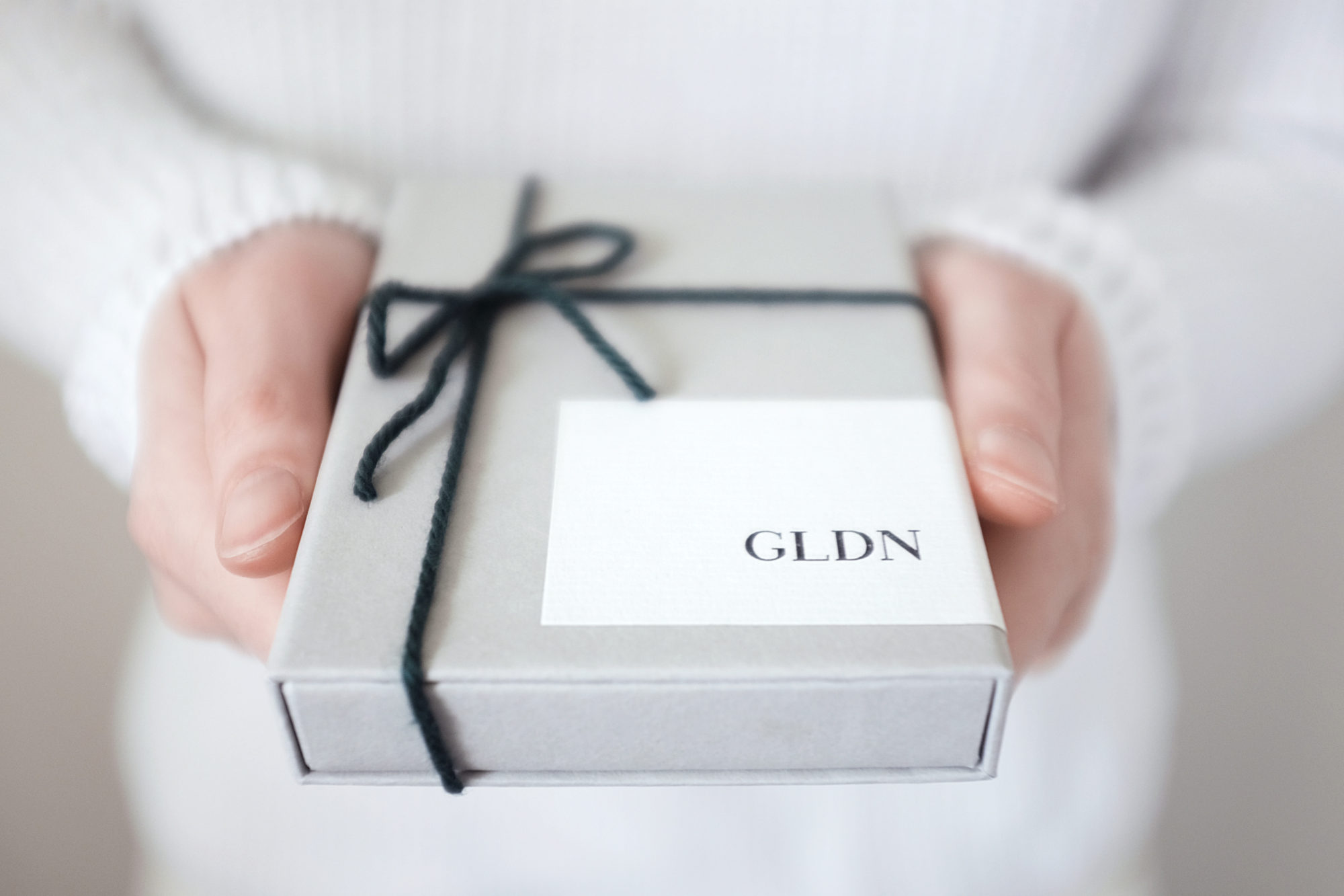 Alyssa holds a GLDN box toward the camera