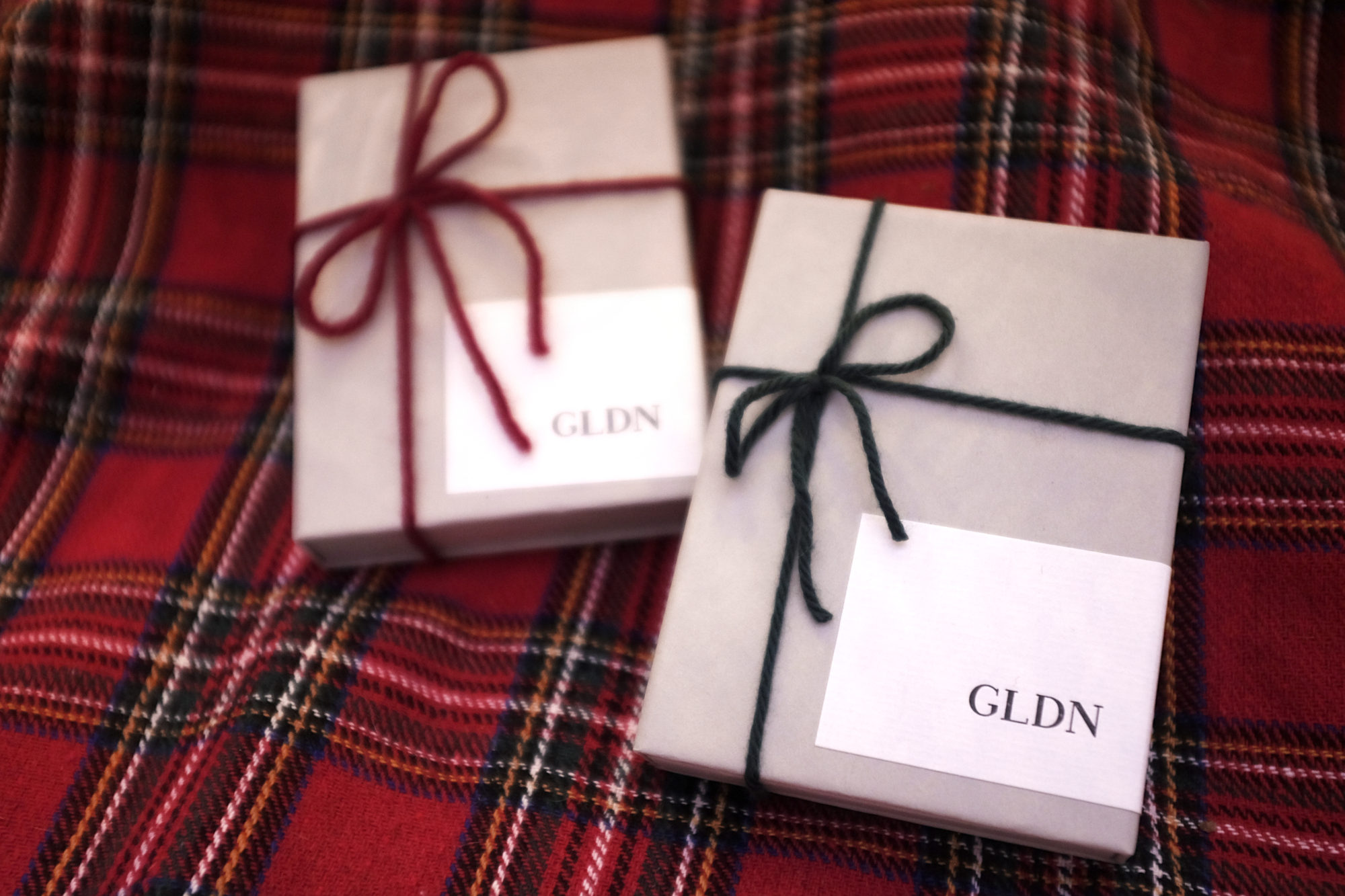 Two GLDN boxes on a red tartan tree skirt