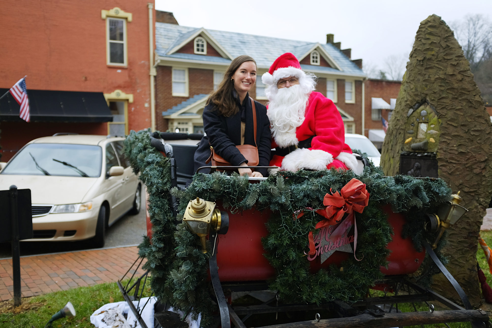 Alyssa sits with Santa in a sleigh