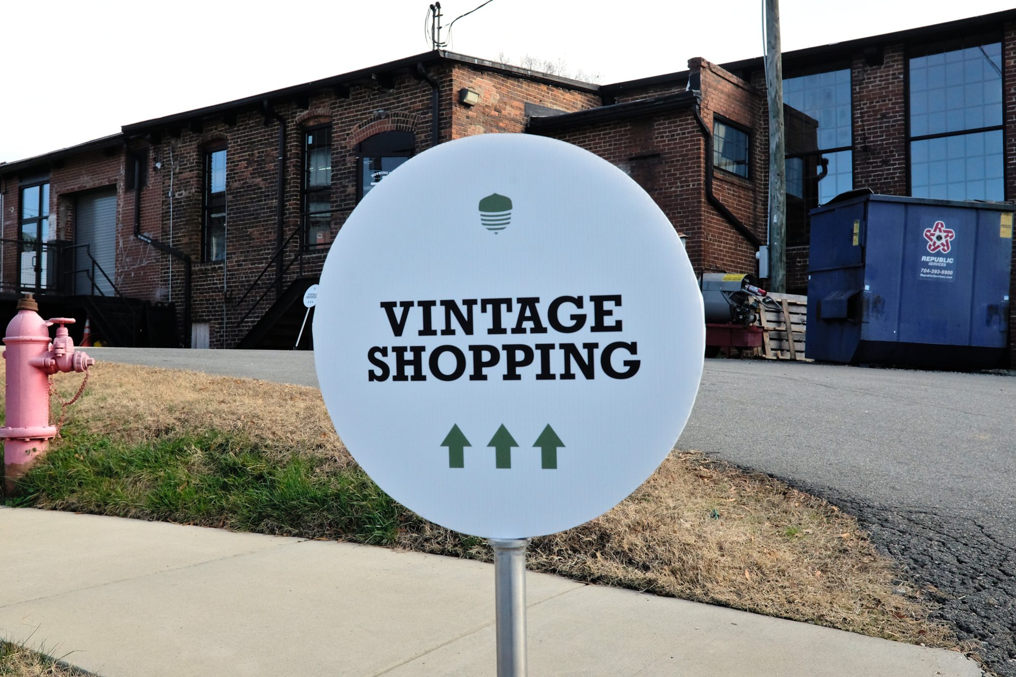 Sign that reads "Vintage Shopping" with arrows pointing ahead