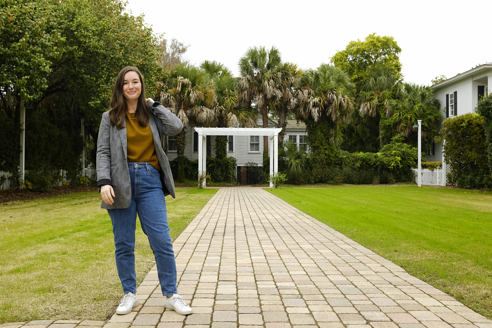 Alyssa wears an olive sweater, blue jeans, and blazer