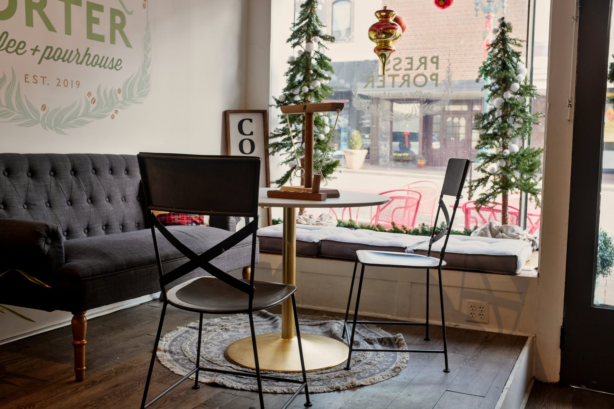 A small table and chairs in the window of Press & Porter in Concord