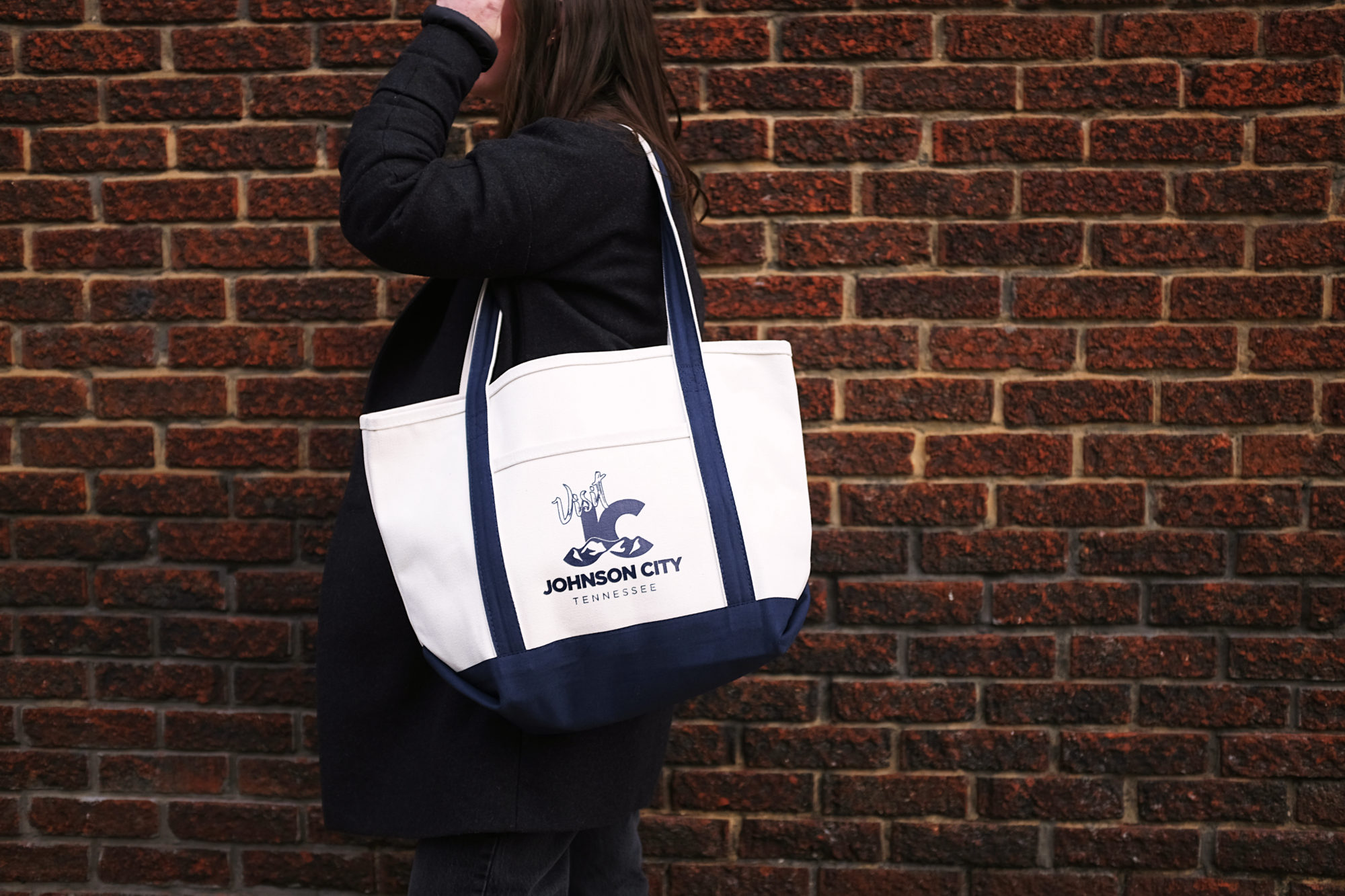 Alyssa carries a tote bag emblazoned with the Visit Johnson City logo