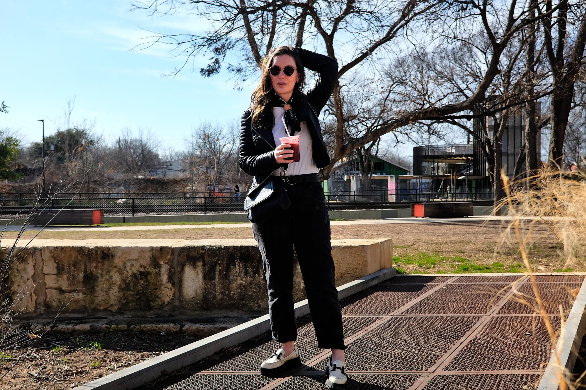 Alyssa stands on a mini bridge holding a cup of juice