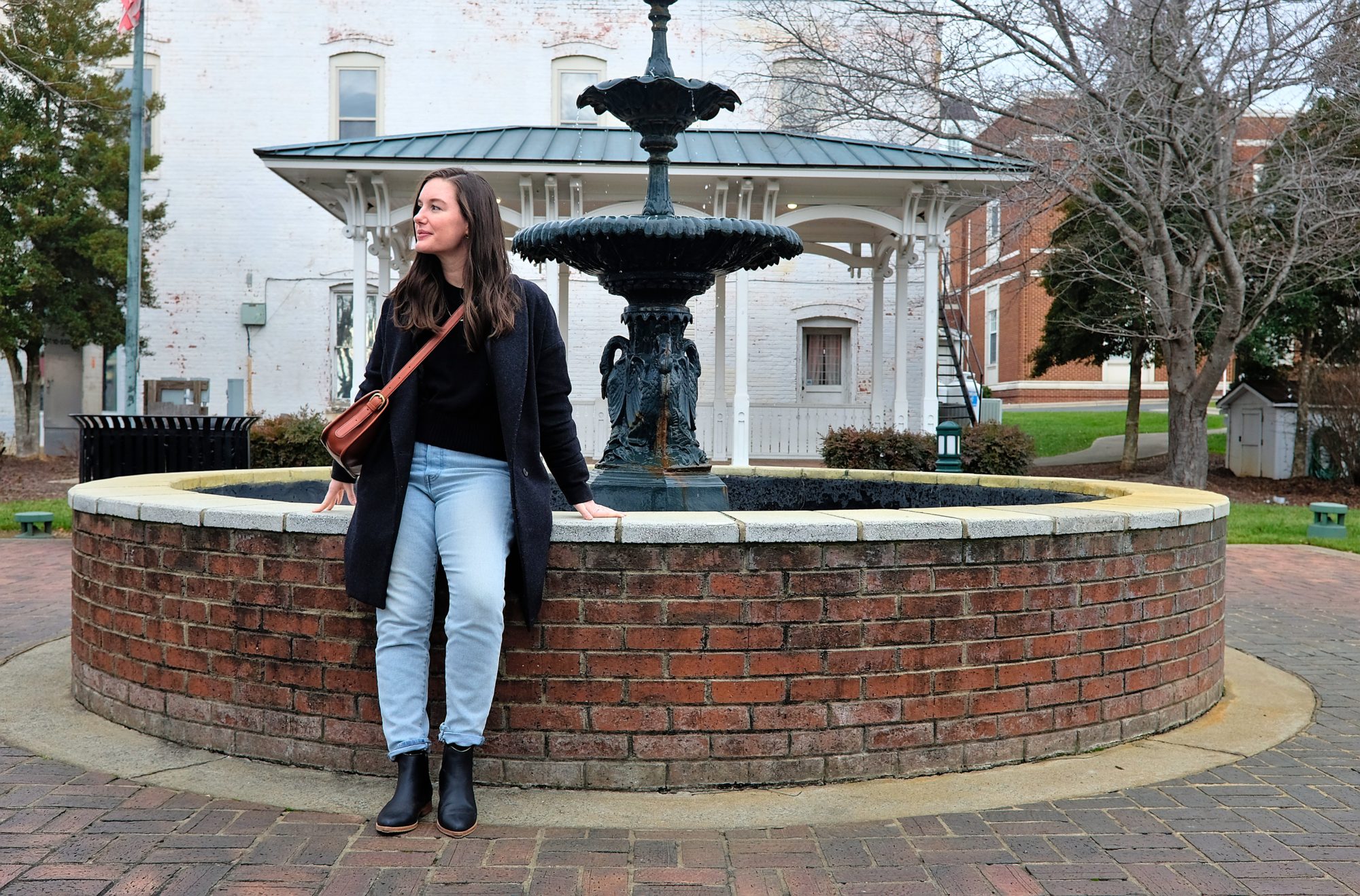 Alyssa leans against the fountain in Courthouse Square Park in Albemarle