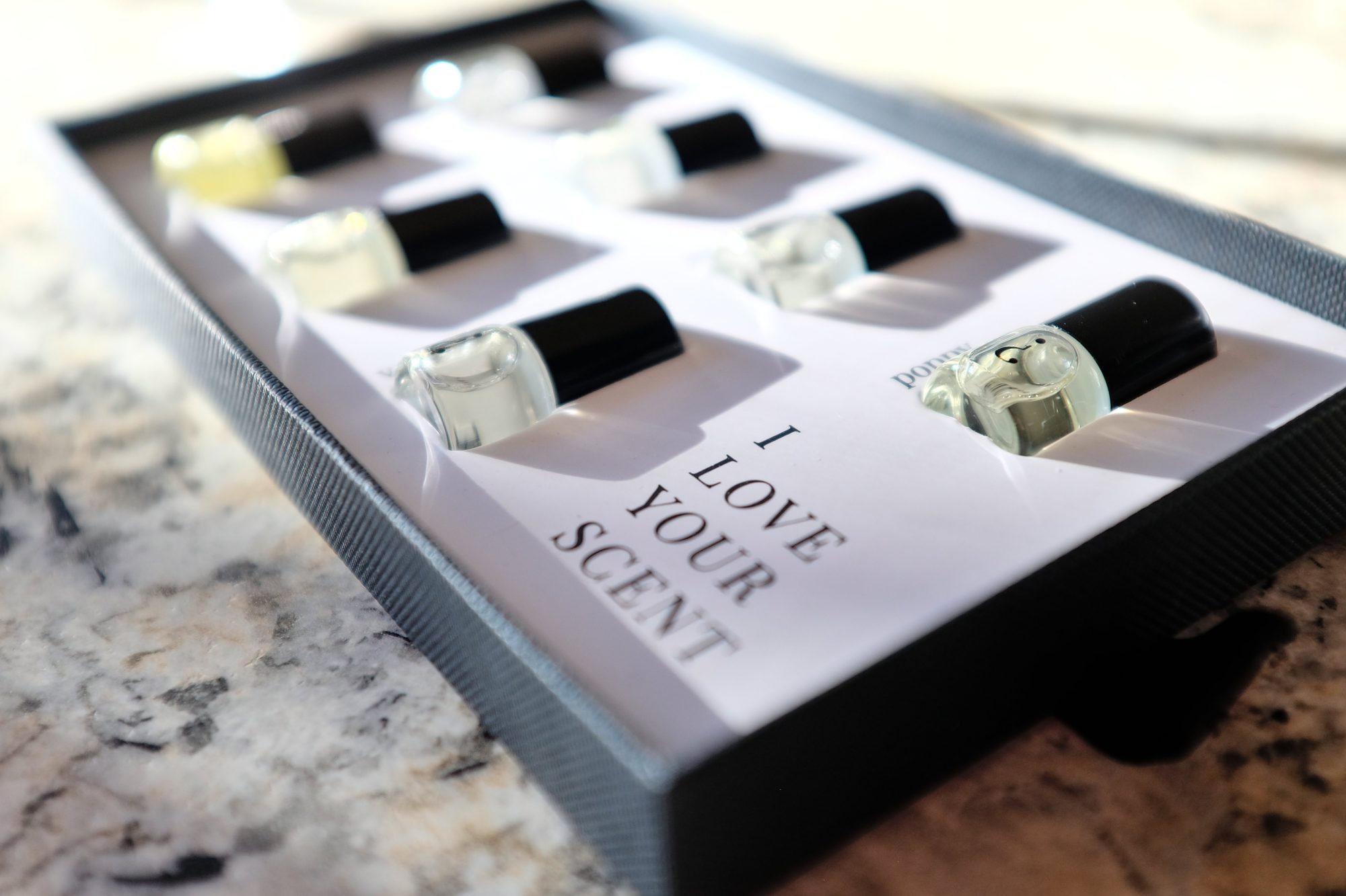 A set of mini bottles sits in a box that reads "I love your scent"
