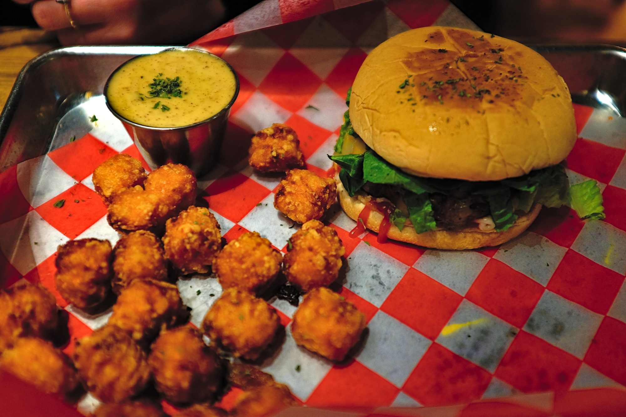 A burger with sweet potato tots at Tiffany's at the Boardroom