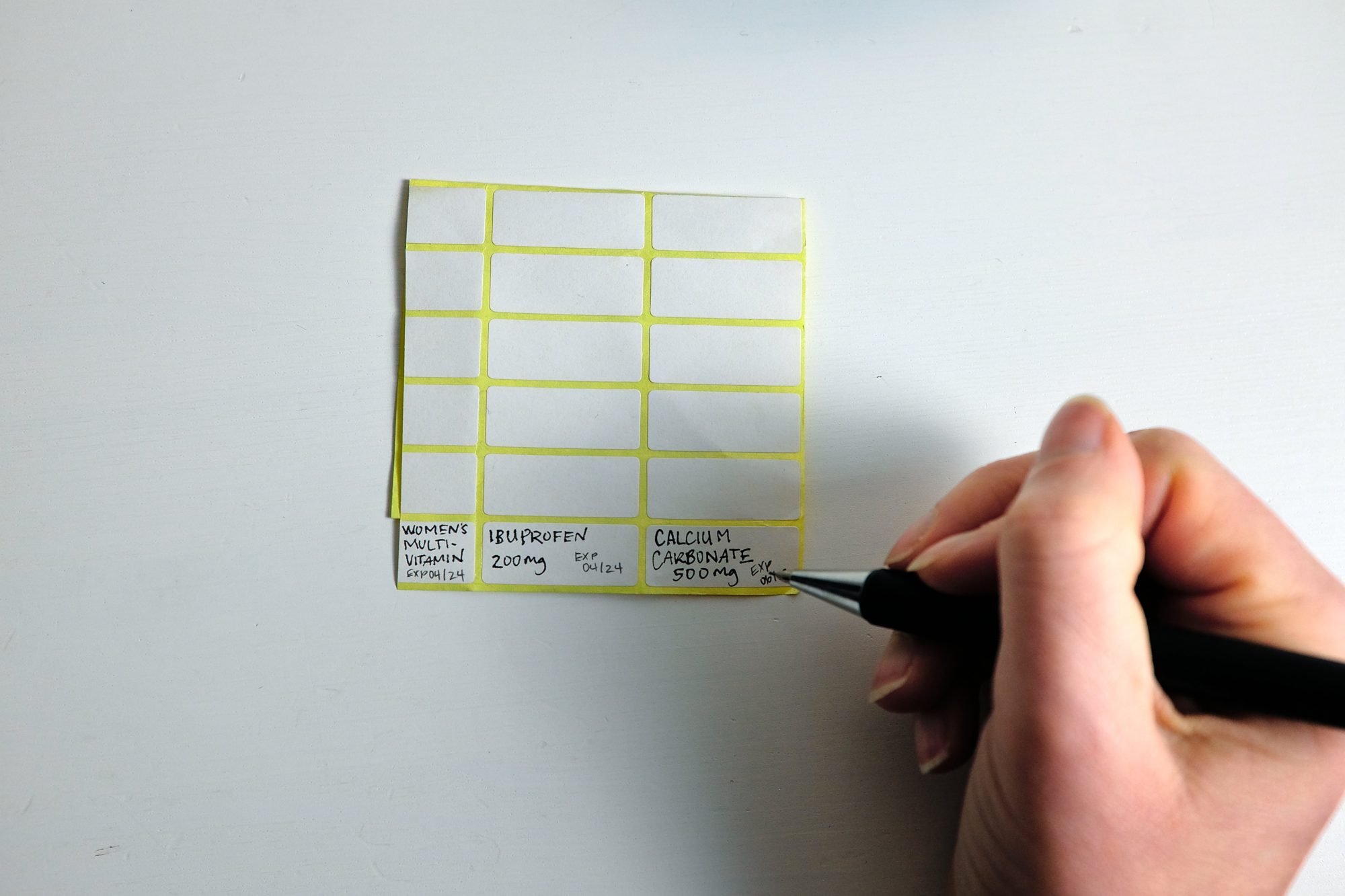 Alyssa writes the generic names of medications on a sheet of labels