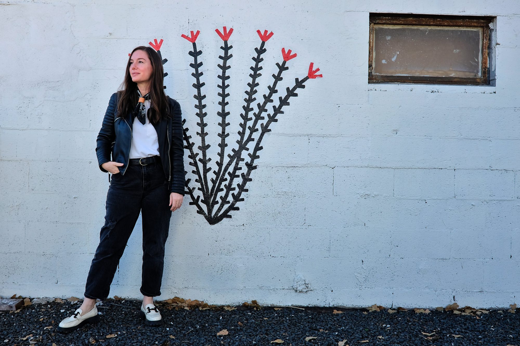 Alyssa stands in front of a cactus painting