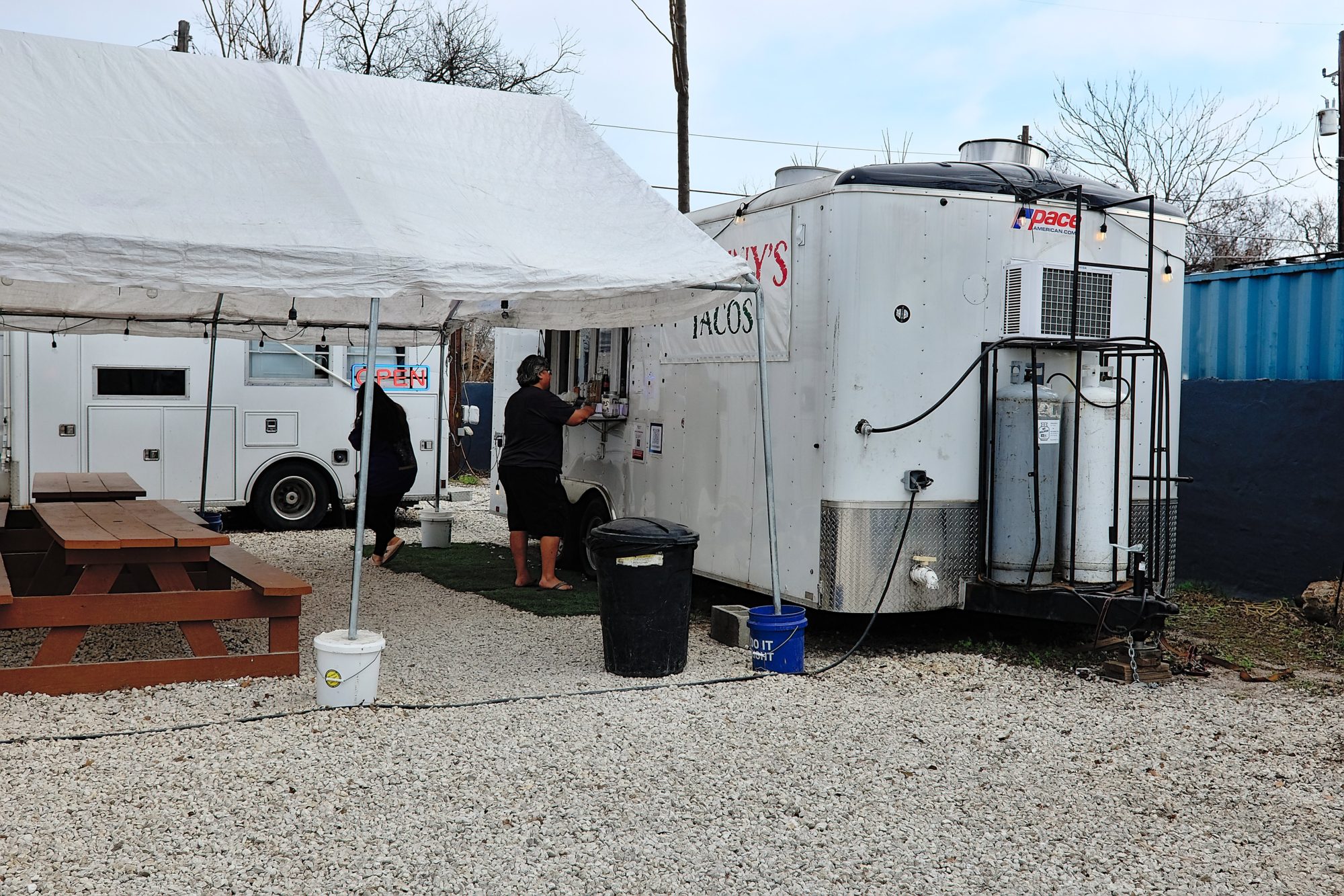 A person orders from a food truck with a sign that says Granny's Tacos