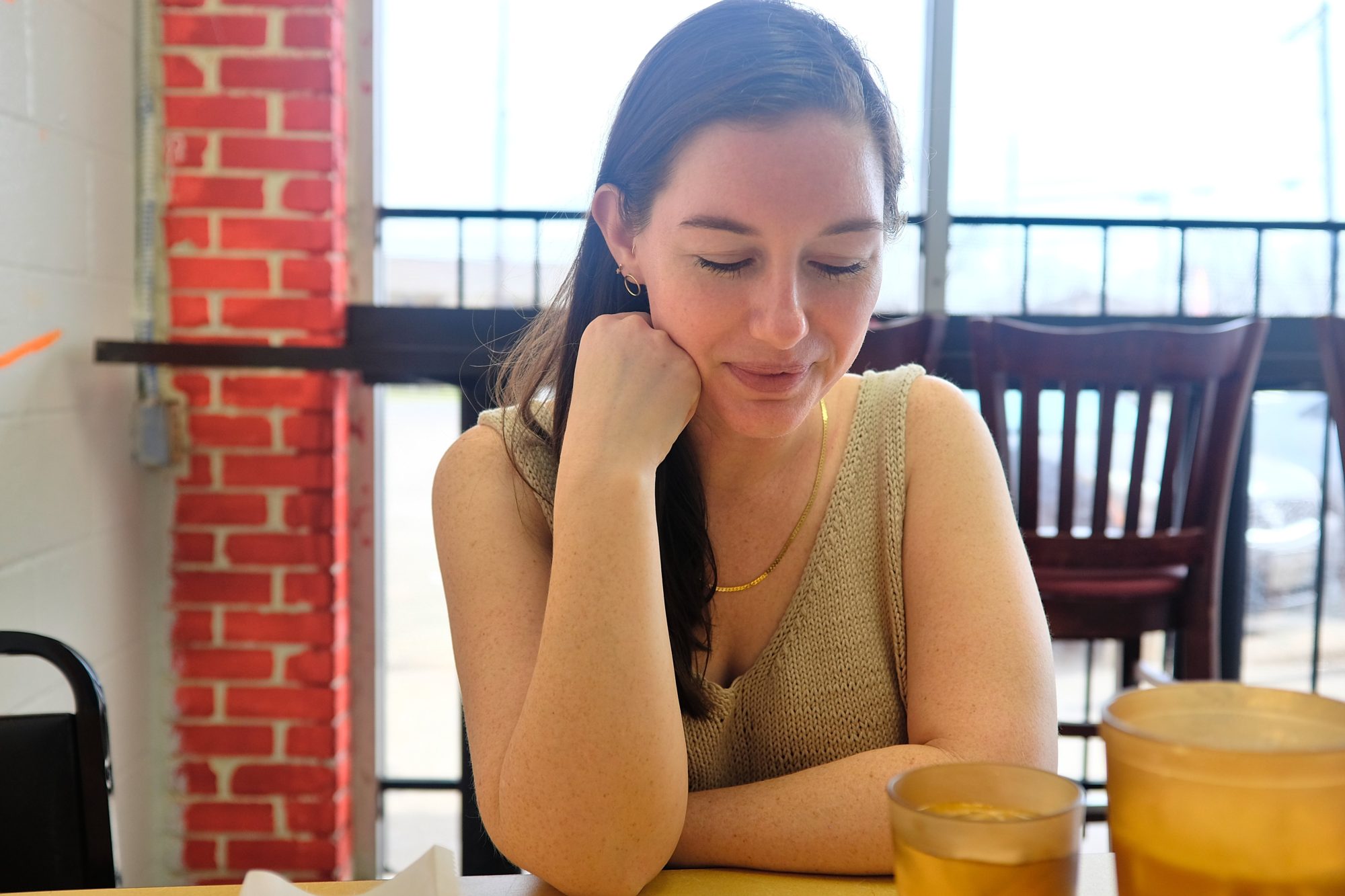 Alyssa sits at a table wearing a handknit tank