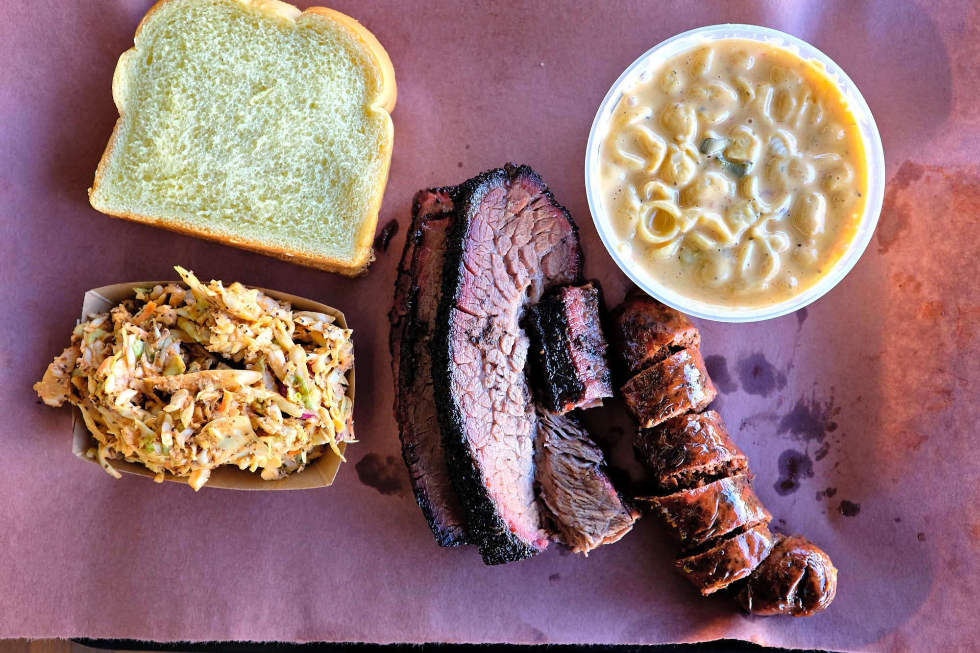A paper-lined tray of meat, bread, mac and cheese, and slaw at la Barbecue