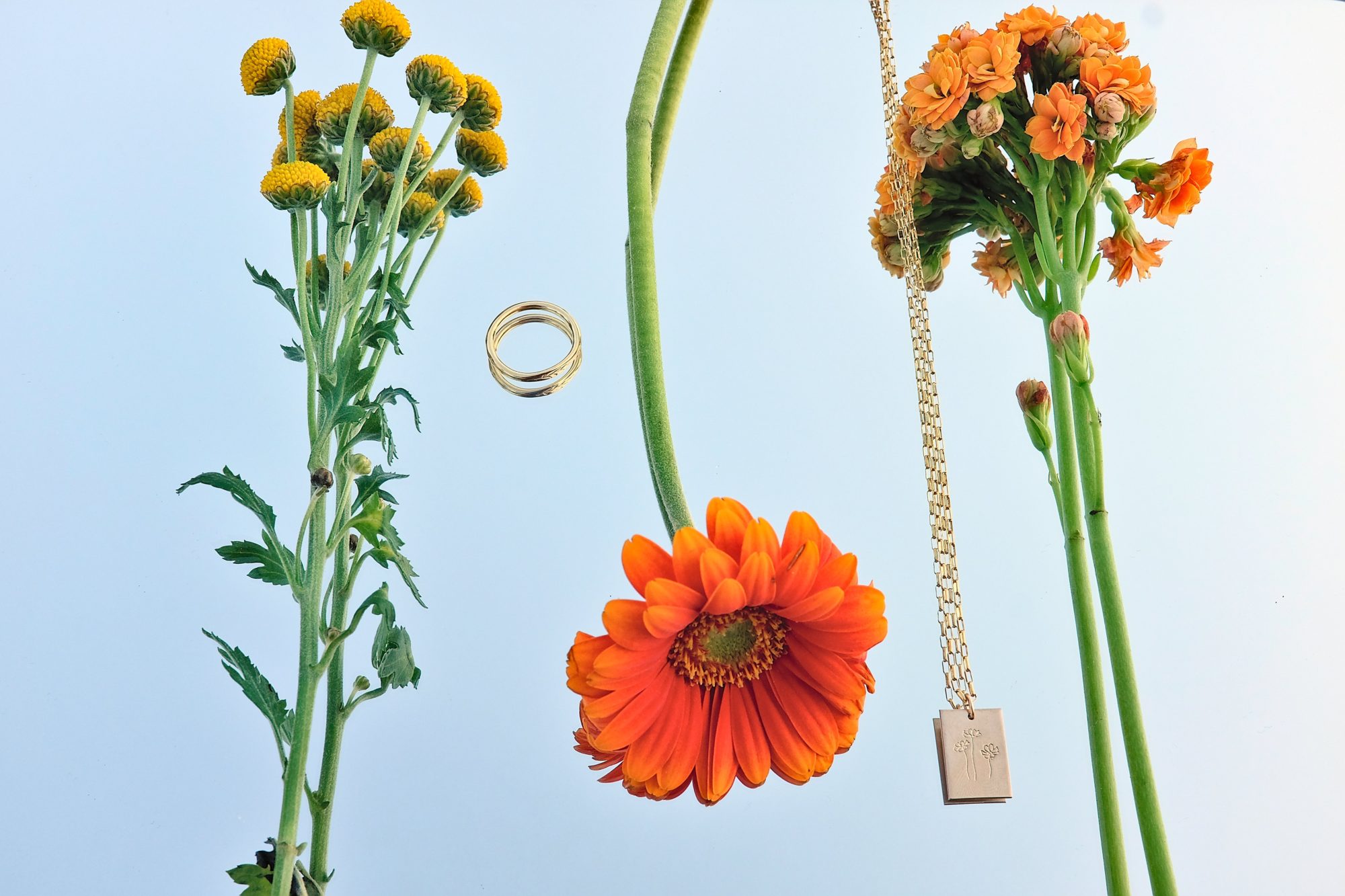 GLDN's Marseille necklace and olive signet ring are mixed in with a three flowers