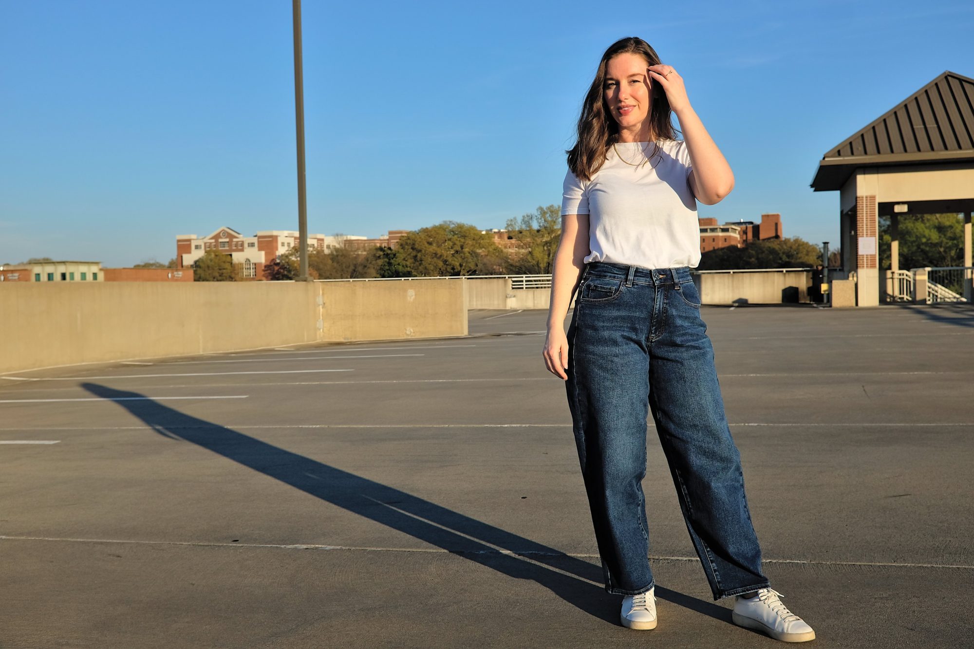 Alyssa wears the Lou High Rise Barrel Leg jean with a white tee and sneakers