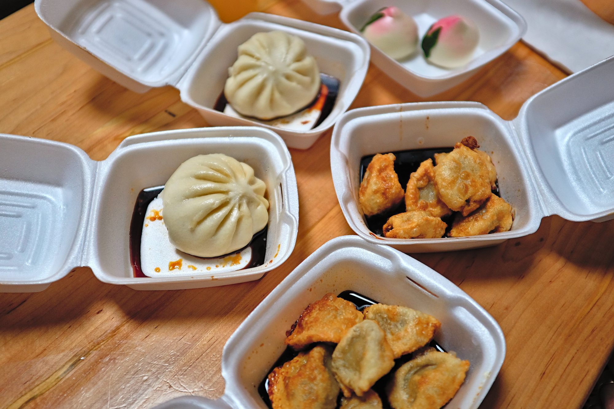 Takeout boxes with steamed buns and dumplings