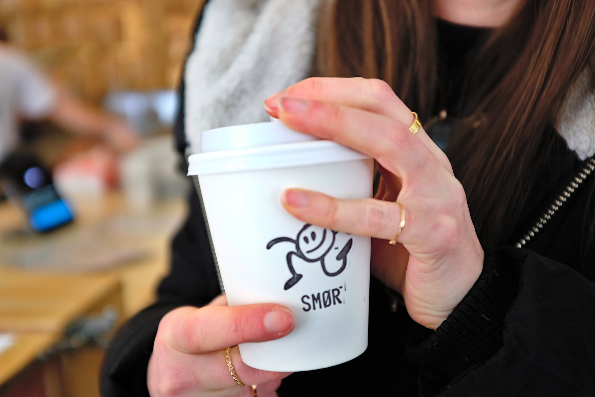 Alyssa holds a cup with multiple gold rings on