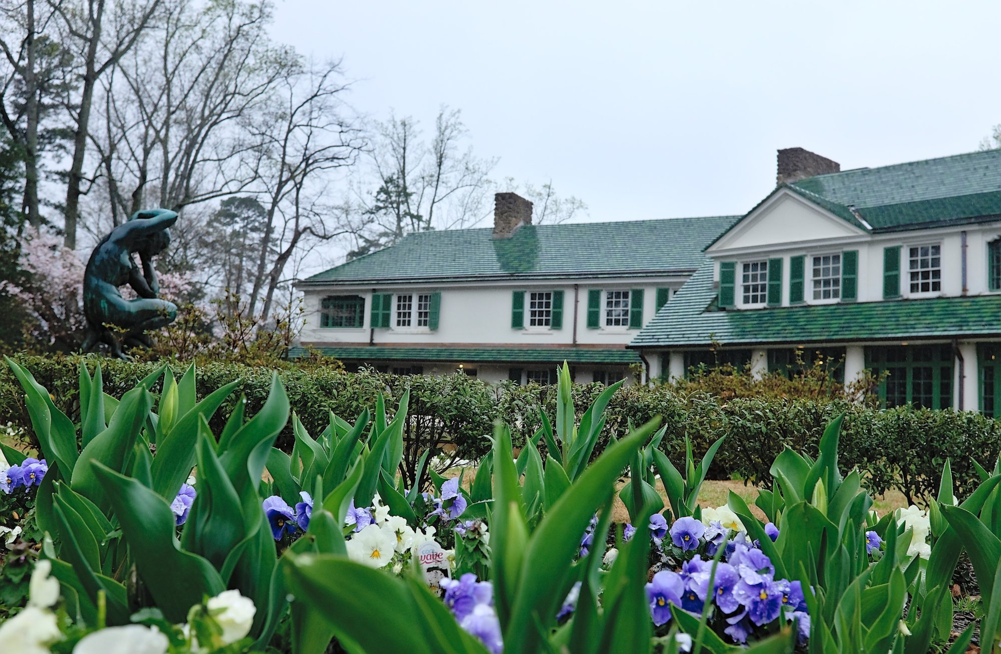 Reynolda House is visible through a patch of flowers