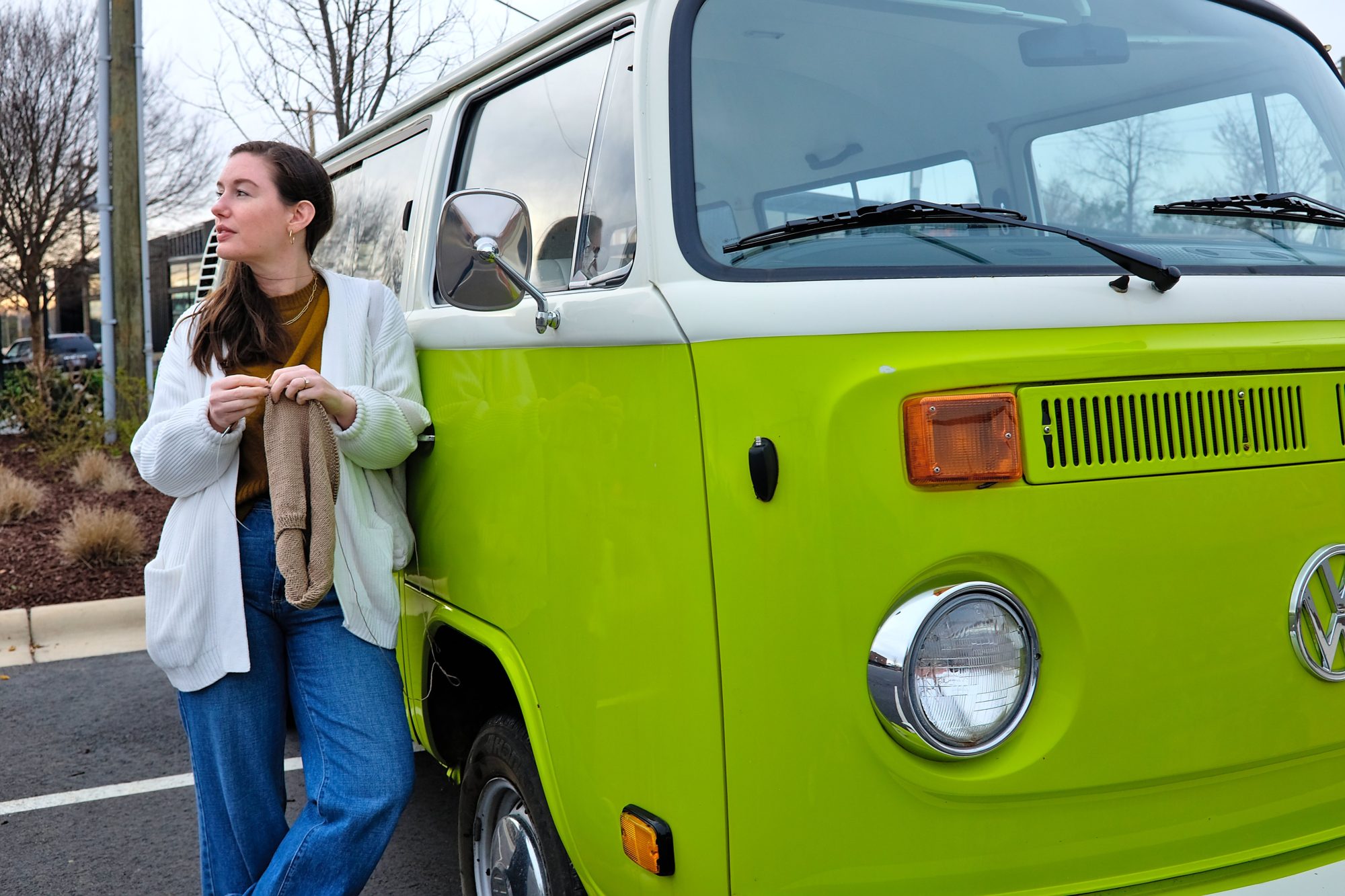 Alyssa stands in front of a VW bus knitting a tank top