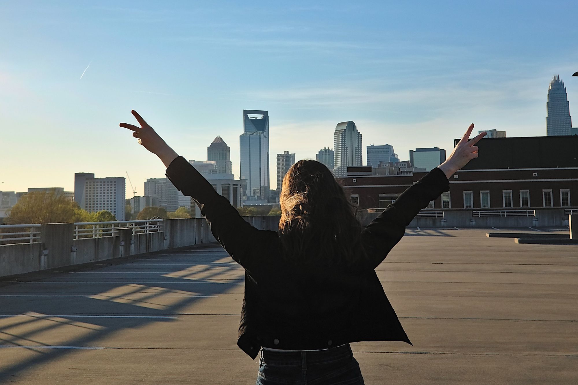 Alyssa gives two peace signs while wearing the black denim jacket