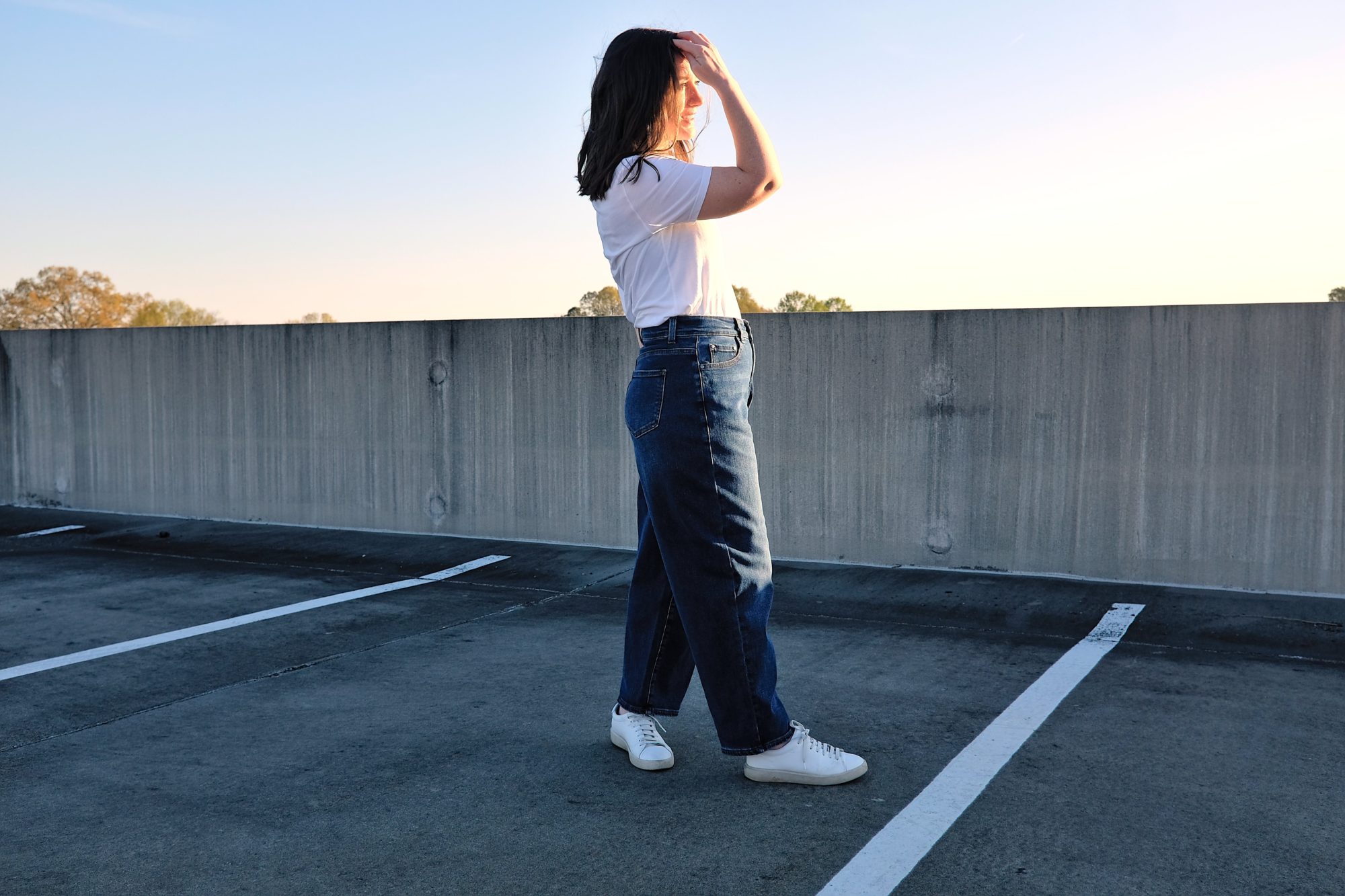 Alyssa wears a pair of jeans on the roof of a parking deck