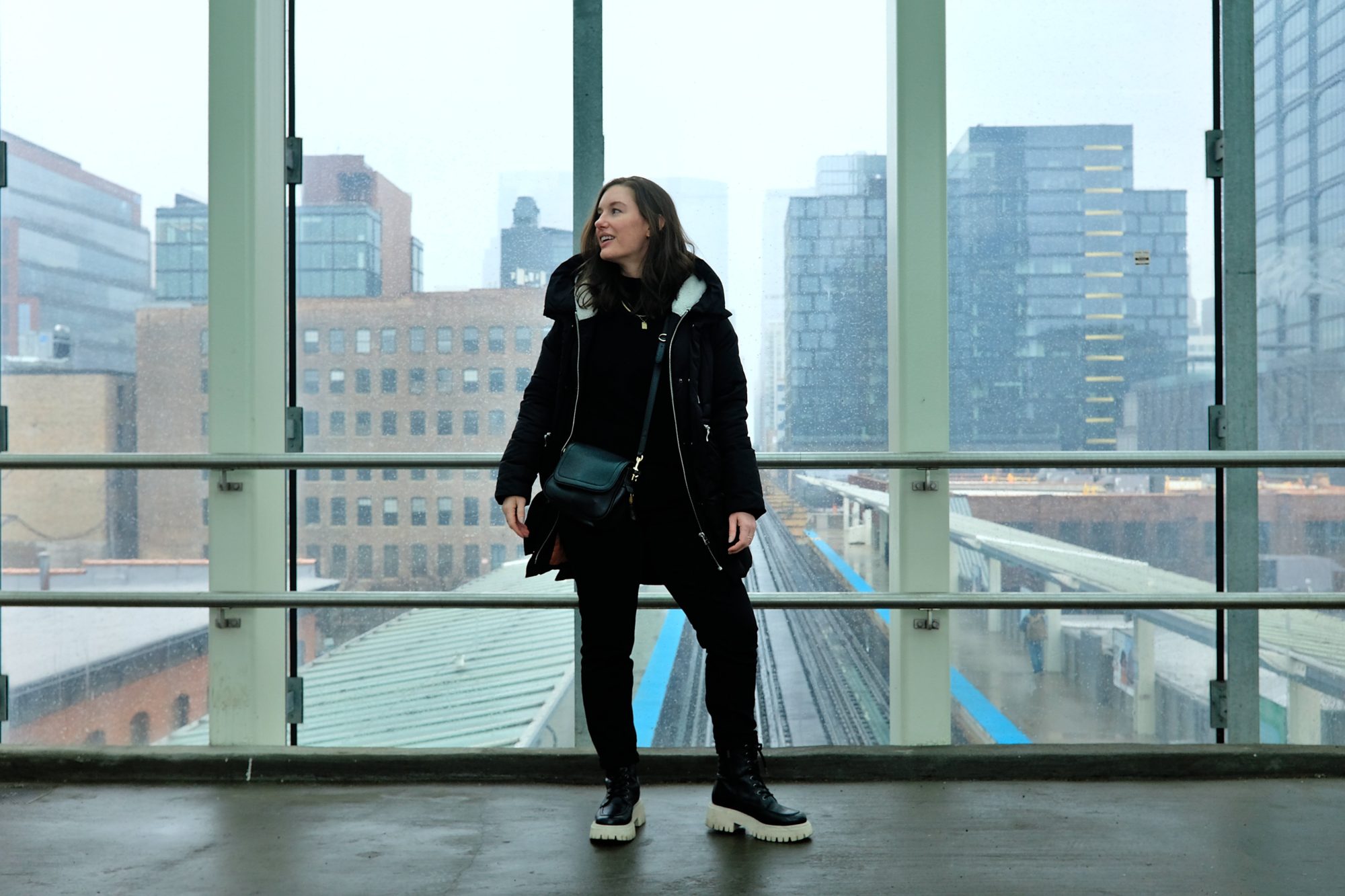 Alyssa stands on a platform over the L tracks