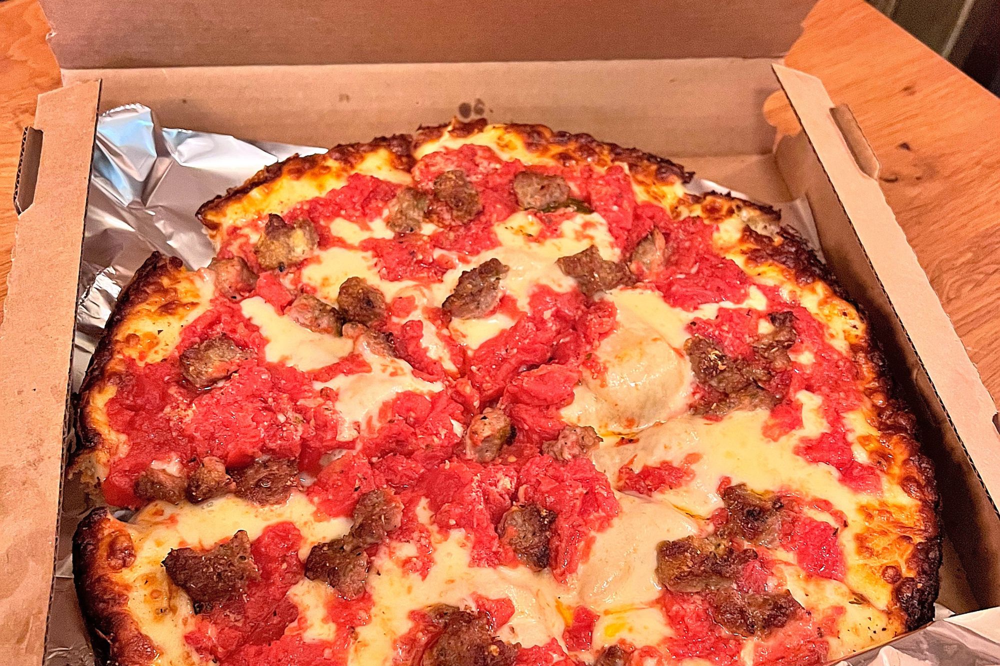 A cardboard box with a deep dish pizza