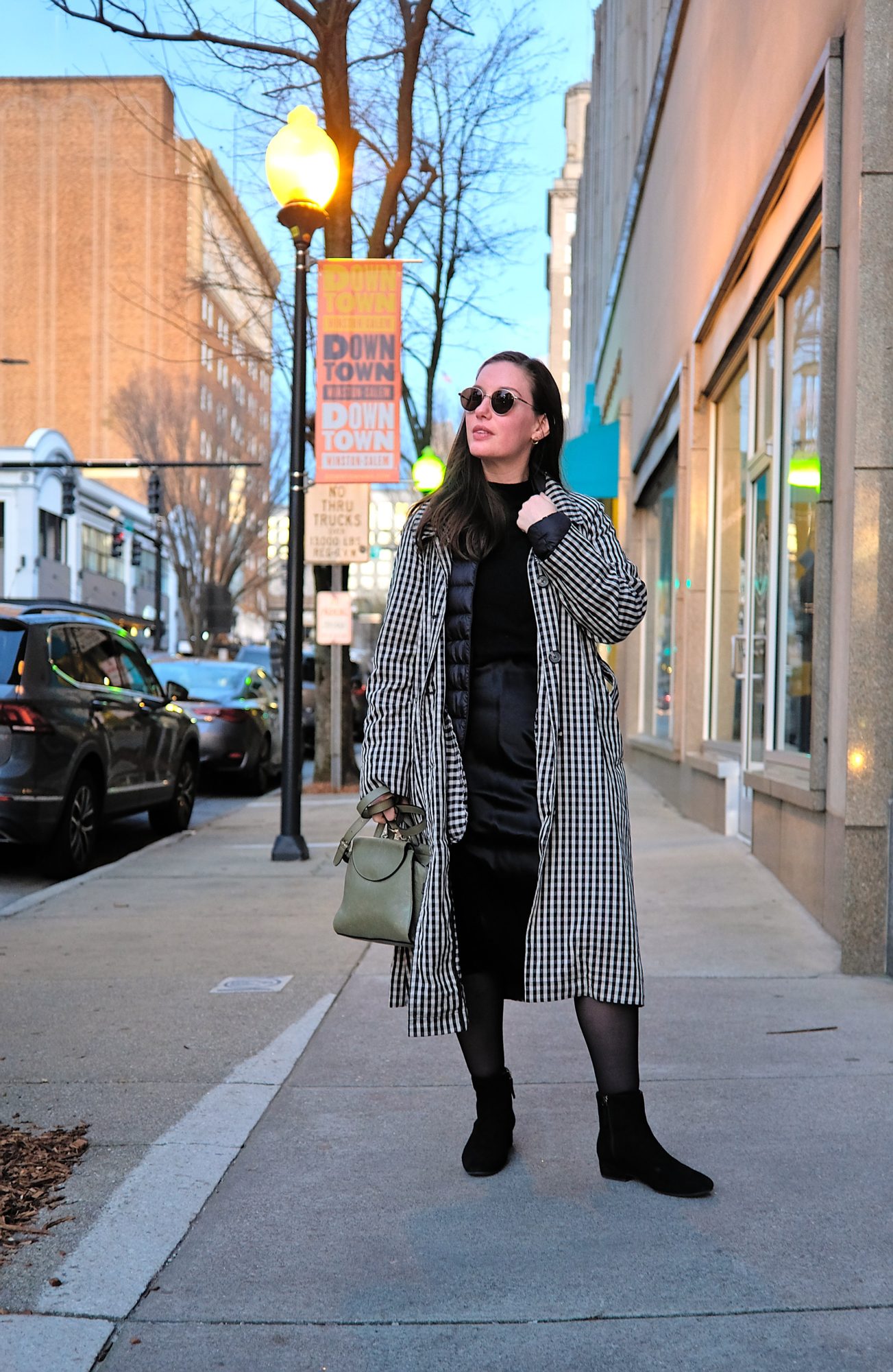 Alyssa wears a dress with a sweater on top in Winston-Salem