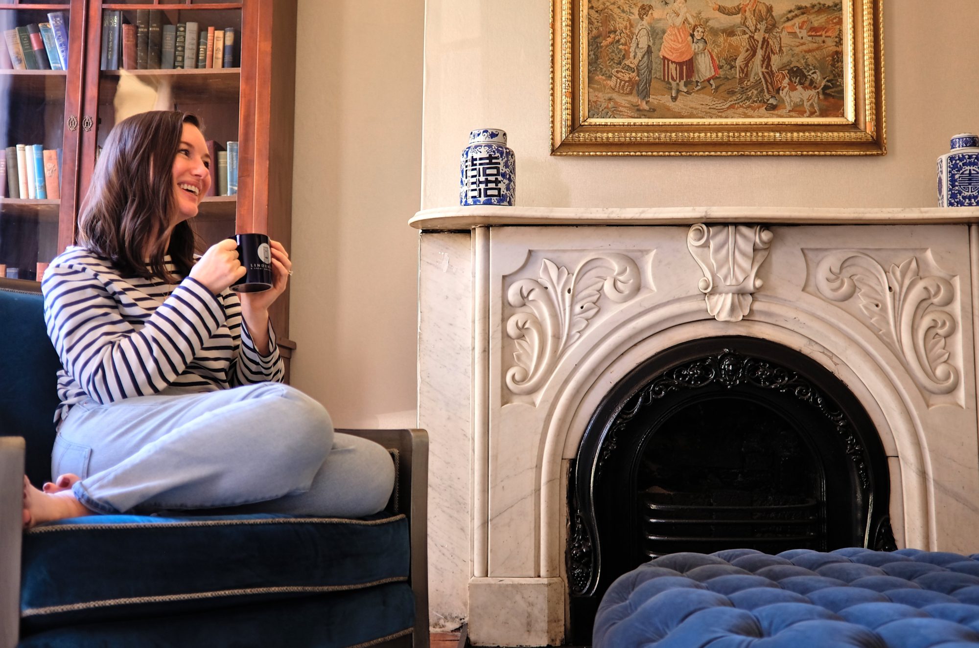 Alyssa drinks a cup of coffee in the parlor