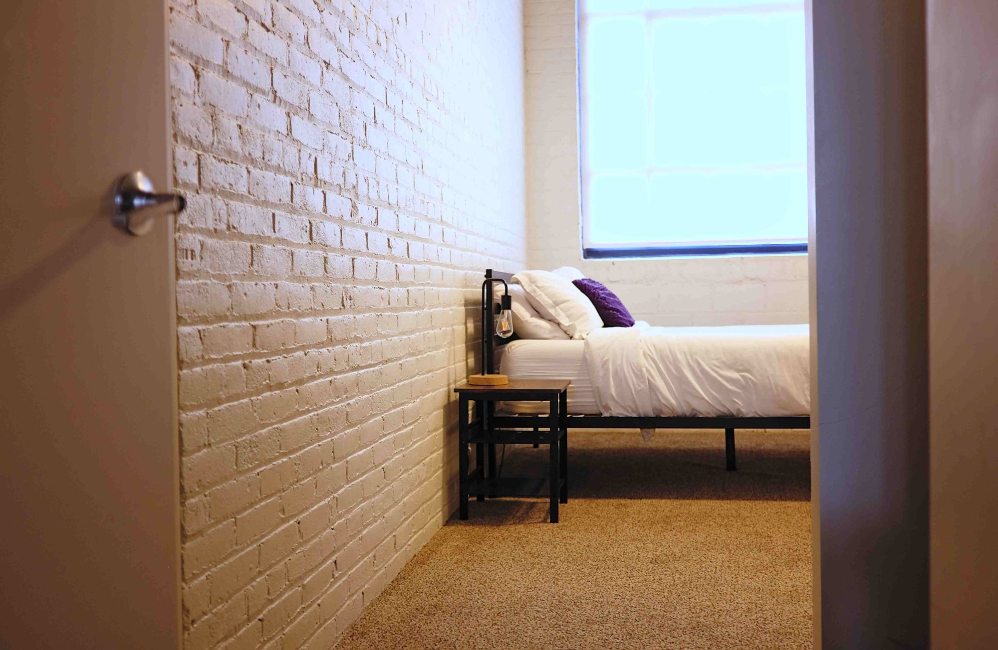 A view of a platform bed and a lamp