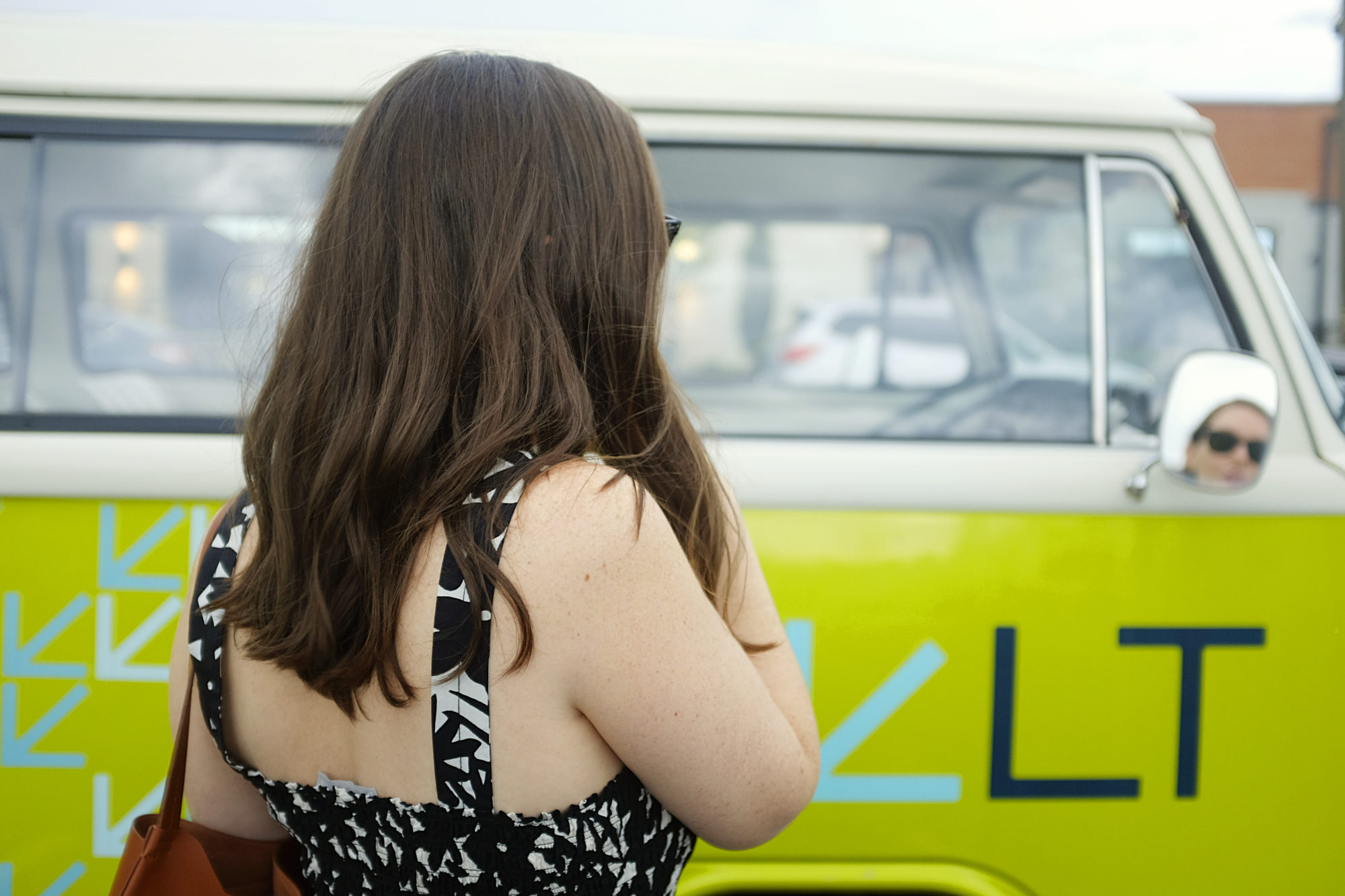 Alyssa looks in the mirror of a VW bus