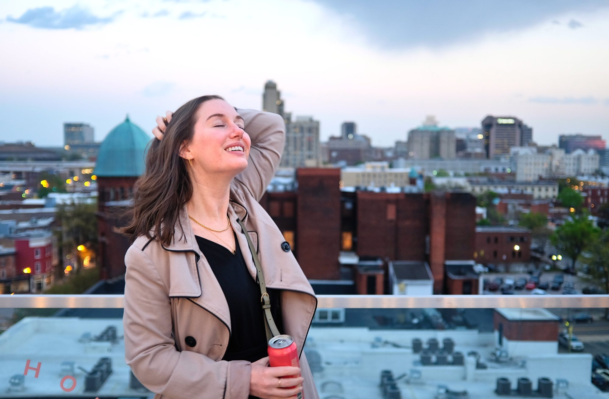 Alyssa runs her hands through her hair at a rooftop bar