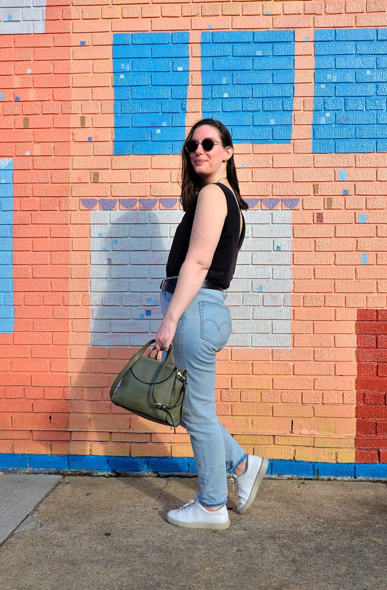 Alyssa walks in front of a colorful mural in Richmond's Carytown neighborhood