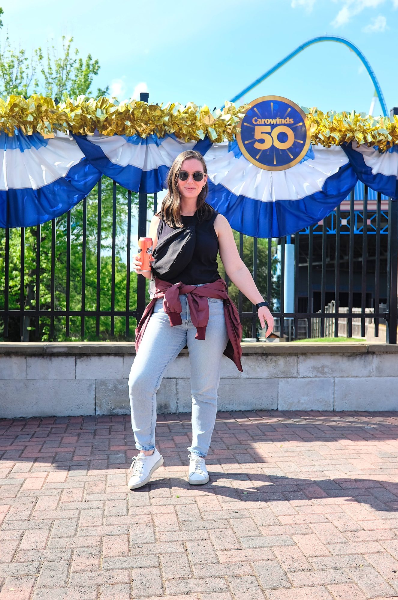 Alyssa stands in front of a sign that reads "Carowinds 50"