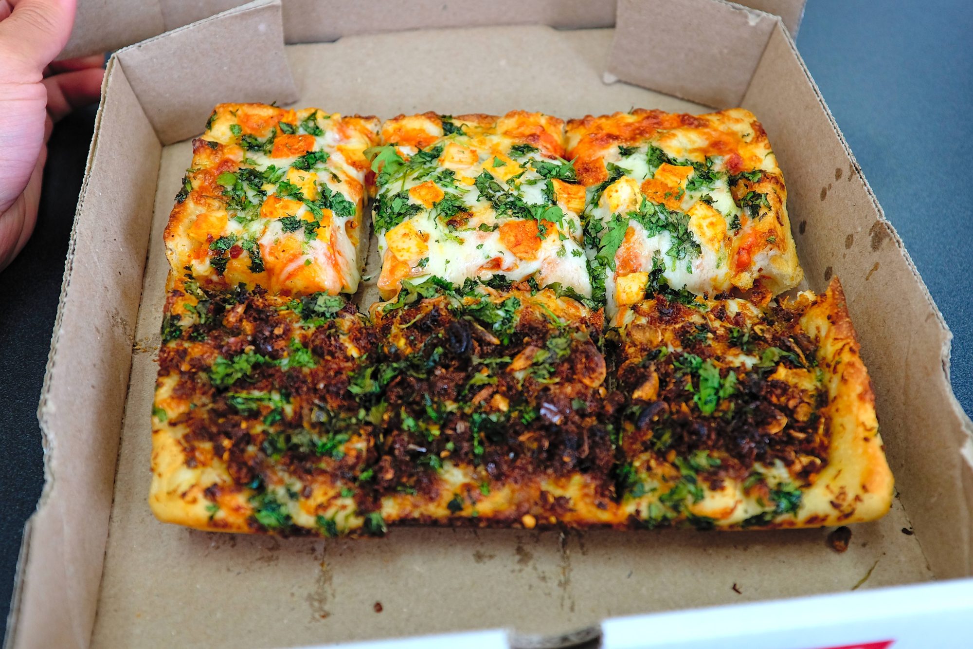 A Detroit pizza with two types of toppings
