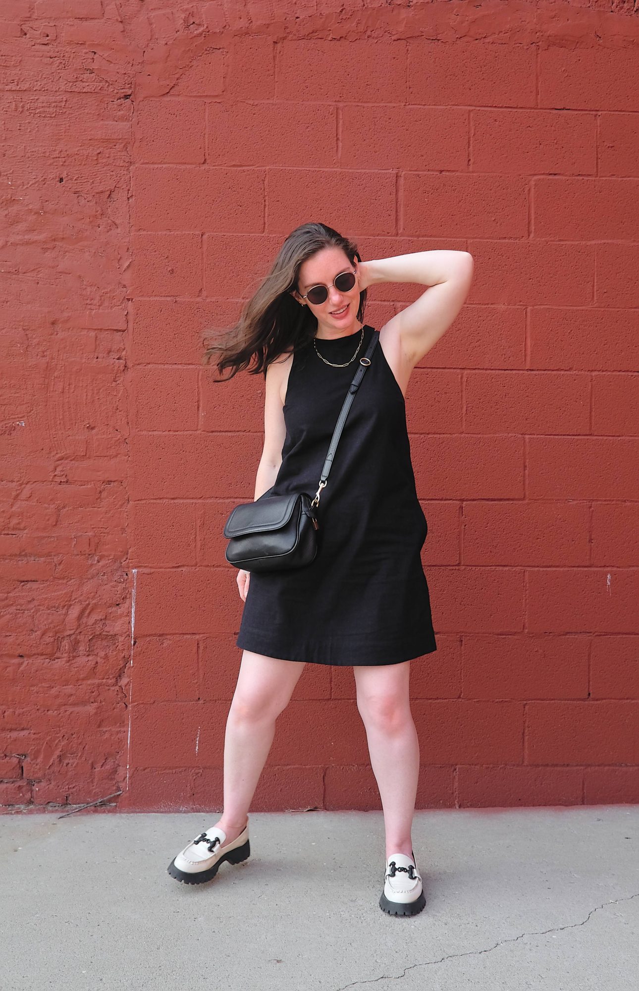 Alyssa wears a black linen dress and white loafers