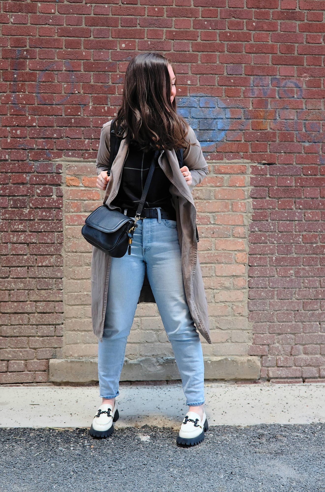 Alyssa wears a black silk print top, jeans, and loafers