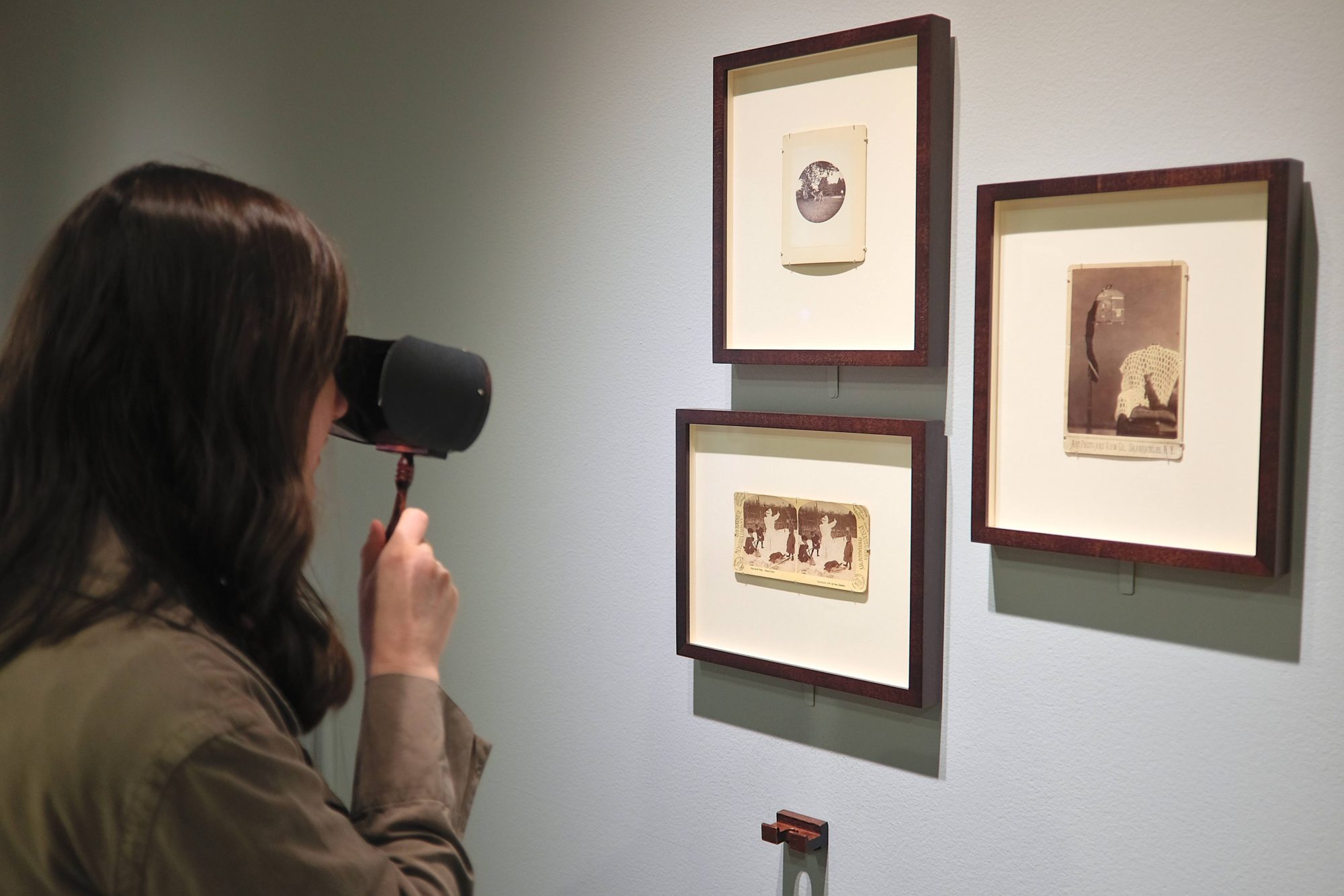 Alyssa peers at photos in an exhibit at the George Eastman Museum